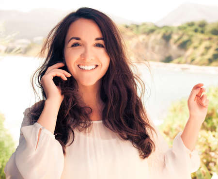 Young brunette woman in white dress. Happy summer time.の写真素材
