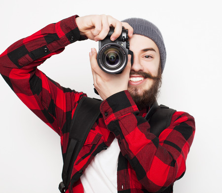 life style, tehnology and people concept: professional photographer. Portrait of confident young man in shirt  holding  camera over white backgroundの写真素材