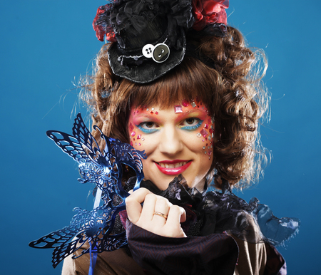 Beautiful curly woman with mask. Carnaval visage. Holiday picture.の写真素材