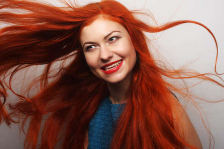 Beautiful young happy woman with long flowing red hairの写真素材