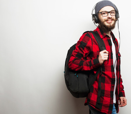 life style, education and people concept:  young bearded man listening to music while standing against grey background. Hipster style.の写真素材