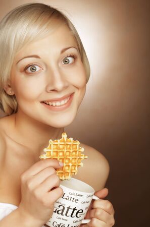 young blond woman with coffee and cookiesの写真素材