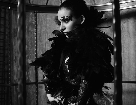 Fashion model in fantasy dress posing in steel cage.の写真素材