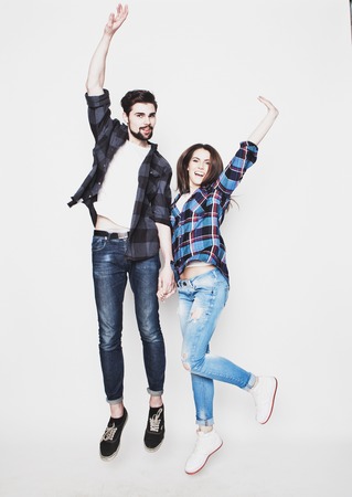 life style, happiness and people concept: Happy loving couple. Jumping over light grey background. Special Fashionable toning.の写真素材