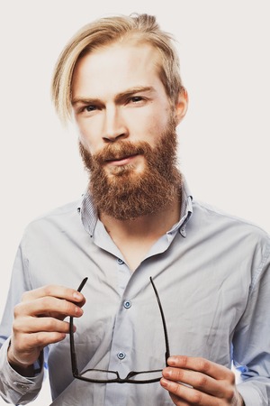 Young bearded hipster man wearing eyeglasses. Over white background.の写真素材
