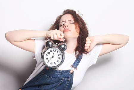 Young fun woman with alarmclockの写真素材