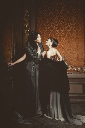two young beautiful women posing in luxury palaceの写真素材