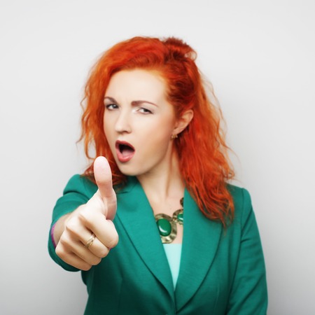 young pretty woman with her finger upの写真素材