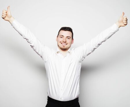life style  and people concept: casual young man in shirt  with both hands raised in the air. Winner and happy.の写真素材
