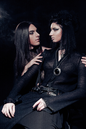 Romantic portrait of young gothic couple - man and woman over dark background.の写真素材