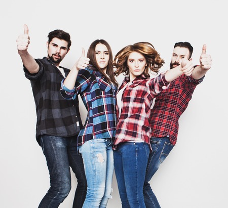 life style, education and people concept:  happy team of students showing thumbs up. Studio shot over white background. Hipster style. Special toning.の写真素材