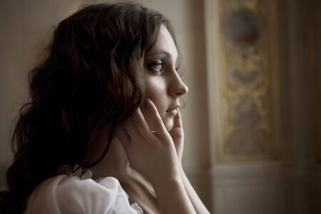 Portrait of a beautiful young victorian lady in white dress.Russian palace.の写真素材