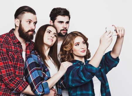 education, technology and people concept: group of students taking selfie with smartphone  over...