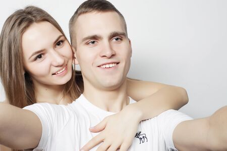 man taking a selfie with her girlfriend isolated on white backgroundの写真素材
