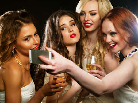 Group of partying girls clinking flutes with sparkling wineの写真素材