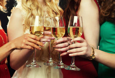 Group of partying girls clinking flutes with sparkling wineの写真素材