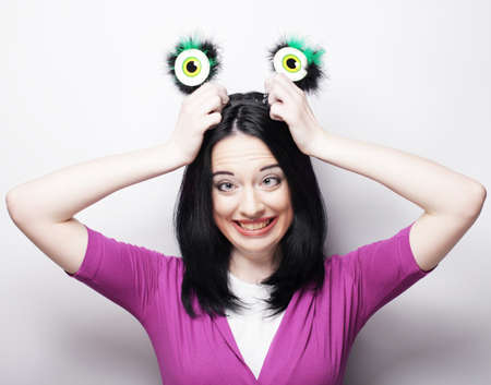 Beautiful young surprised woman with funny green eyes. Studio shot.の写真素材