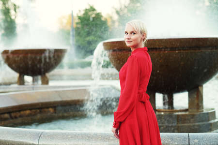 Fashionable young blond woman wearing red dress, summer dayの写真素材