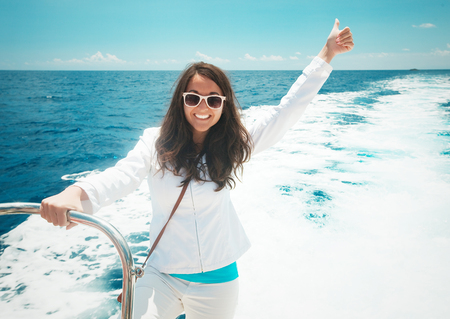 Portrait of a relaxing happy woman on the upper deck of a cruise shipの写真素材