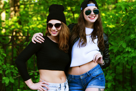 Two young hipster girl friends together having fun. Outdoors, lifestyle.の写真素材