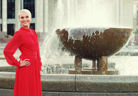 Fashionable young blond woman wearing red dress, summer dayの写真素材