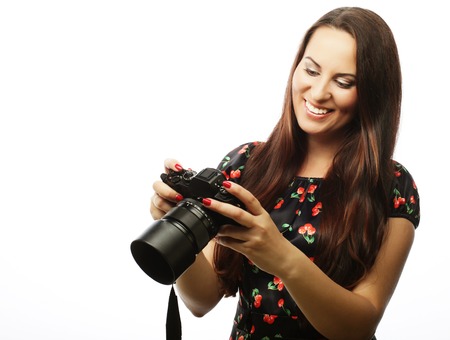 Cheerful young woman making photo on camera over white background