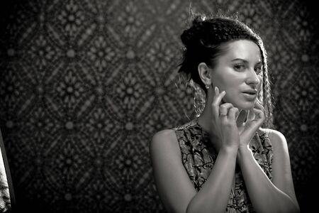 Portrait of pretty young woman with curly hair. Sepia tone.の写真素材