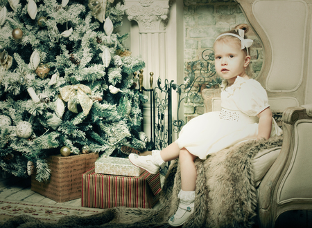 little girl near cristmass tree, holiday pictureの写真素材