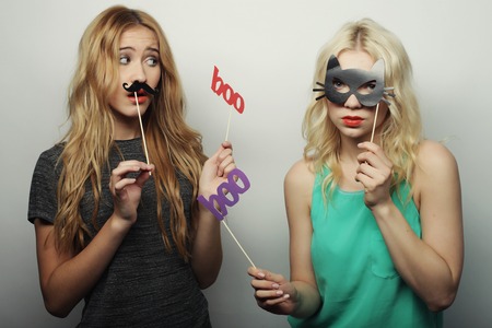 two stylish sexy hipster girls best friends ready for party, over gray backgroundの写真素材
