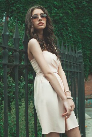 Beautiful brunette young woman wearing dress and walking on the street, Saint Petersburg, Russiaの写真素材