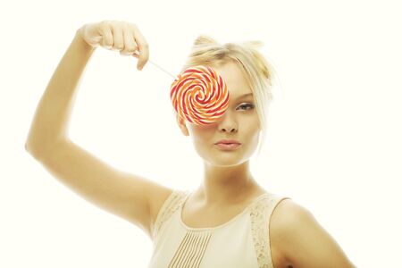 fashion blond woman  holding lollipop, posing against white backgroundの写真素材