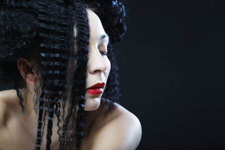 Young beautiful woman with curly hair and red lips. Glamour fashion portrait.の写真素材