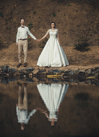 Honeymoon. The bride and groom hugging on the shore of Lake.の写真素材