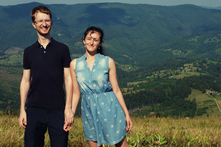 Beautiful young couple hugging and kissing on a summer holiday, Mountain, outdoors. Romantic travel and healthy lifestyle, exterior.の写真素材