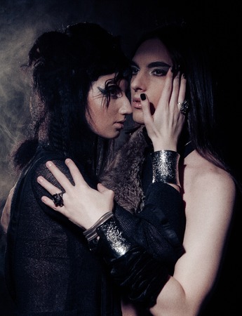 Romantic portrait of young gothic couple - man and woman over dark background.の写真素材