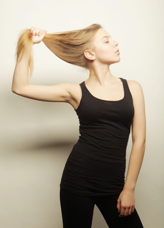 Beautiful woman with long blond hair. Fashion model posing at studio.の写真素材