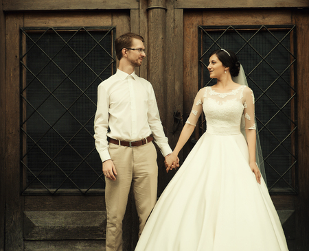 stylish luxury  bride and elegant groom, hugging with tenderness,on the background of the old city Lvivの写真素材