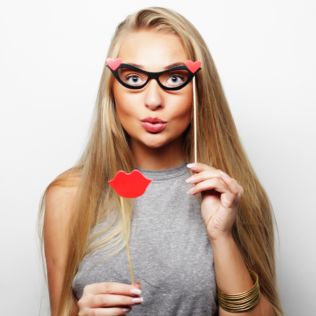 Party image. Playful young woman holding a party glasses. Ready for good time.の写真素材