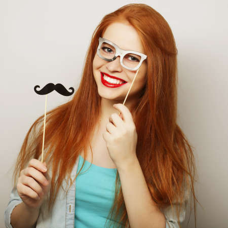 Young woman wearing fake mustaches. Ready for party.の写真素材