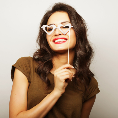 Party image. Playful young woman holding a party glasses. Ready for good time.の写真素材