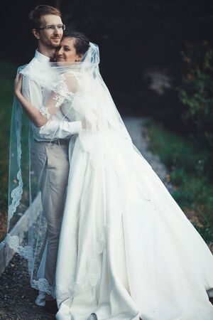 A young bride and groom standing together outdoor, summer time