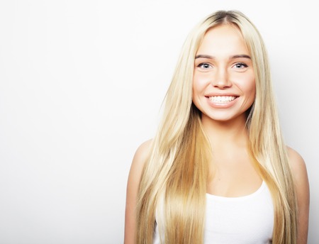 Young cute smiling blond girl on white backgroundの写真素材