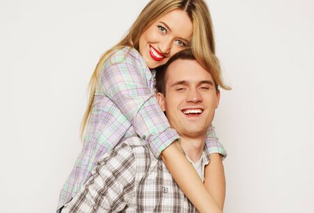 love, family and people concept:   lovely couple,  young man carrying girlfriend on his back.の写真素材