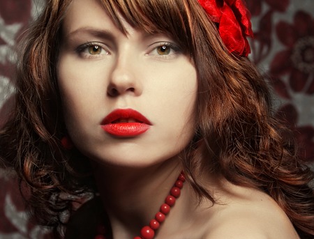 young beautiful girl with red flower in hairの写真素材