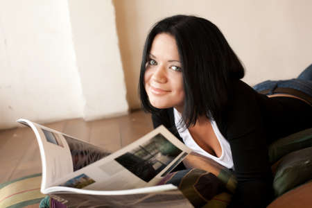 young woman is reading the magazineの写真素材