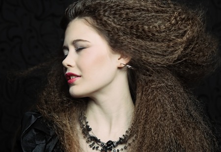 High fashion model in black dress, with creative hairstyling on black backgroundの写真素材