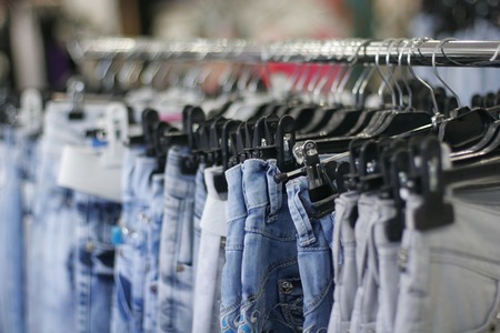 Row of hanged blue jeans in a shopの写真素材