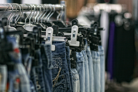Row of hanged blue jeans in a shopの写真素材