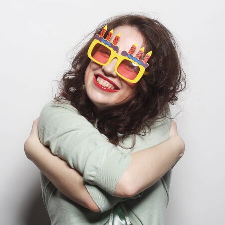 Positive energy portrait of happy funny woman with bright holiday glasses