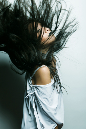 Fashion portrait of asian girl with hair lightly fluttering in the windの写真素材